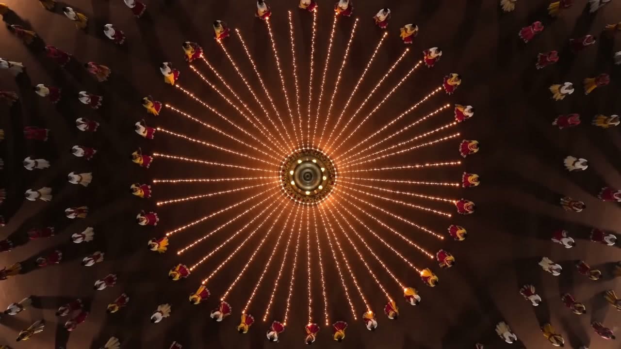 Garba dancers under warm stage light at an open air night celebration