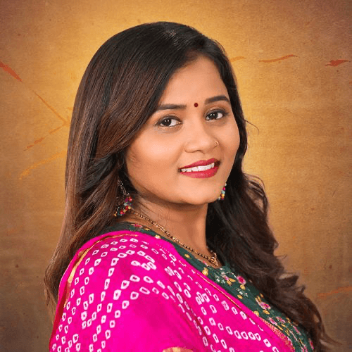Tejal Thakor in a bright pink bandhani print saree, smiling over her shoulder against a warm golden backdrop.